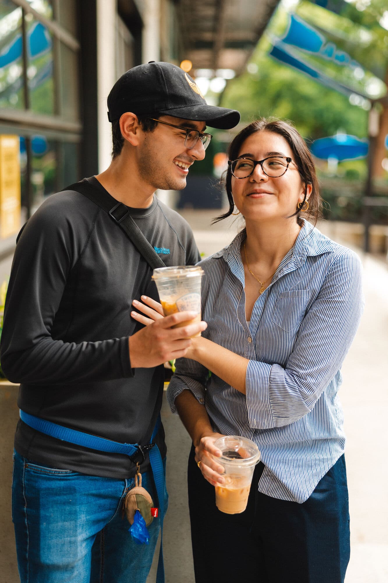 Two guests laughing with iced coffees at a Twin Fins pop-up