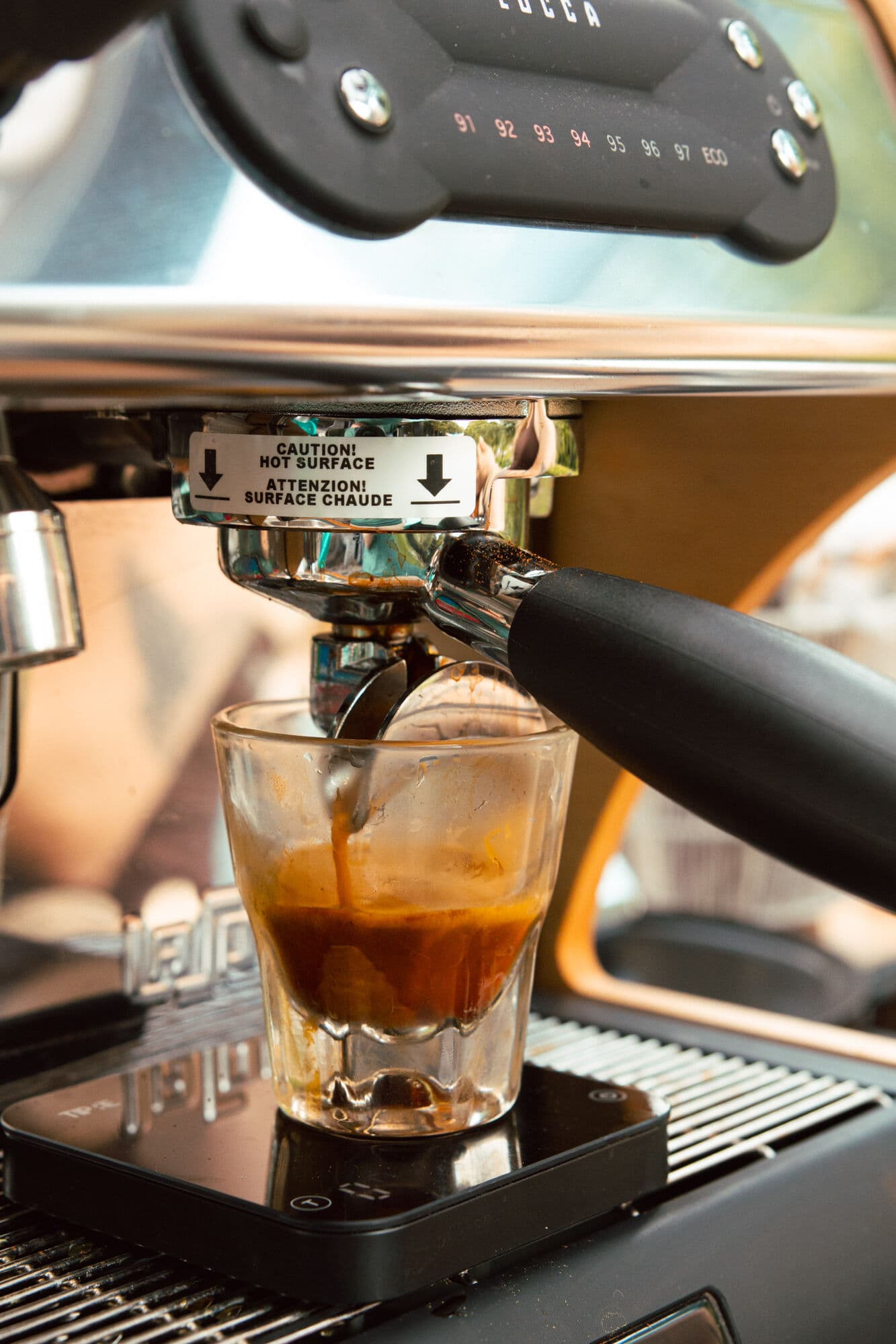 A double espresso pulling into a glass on the cart's machine