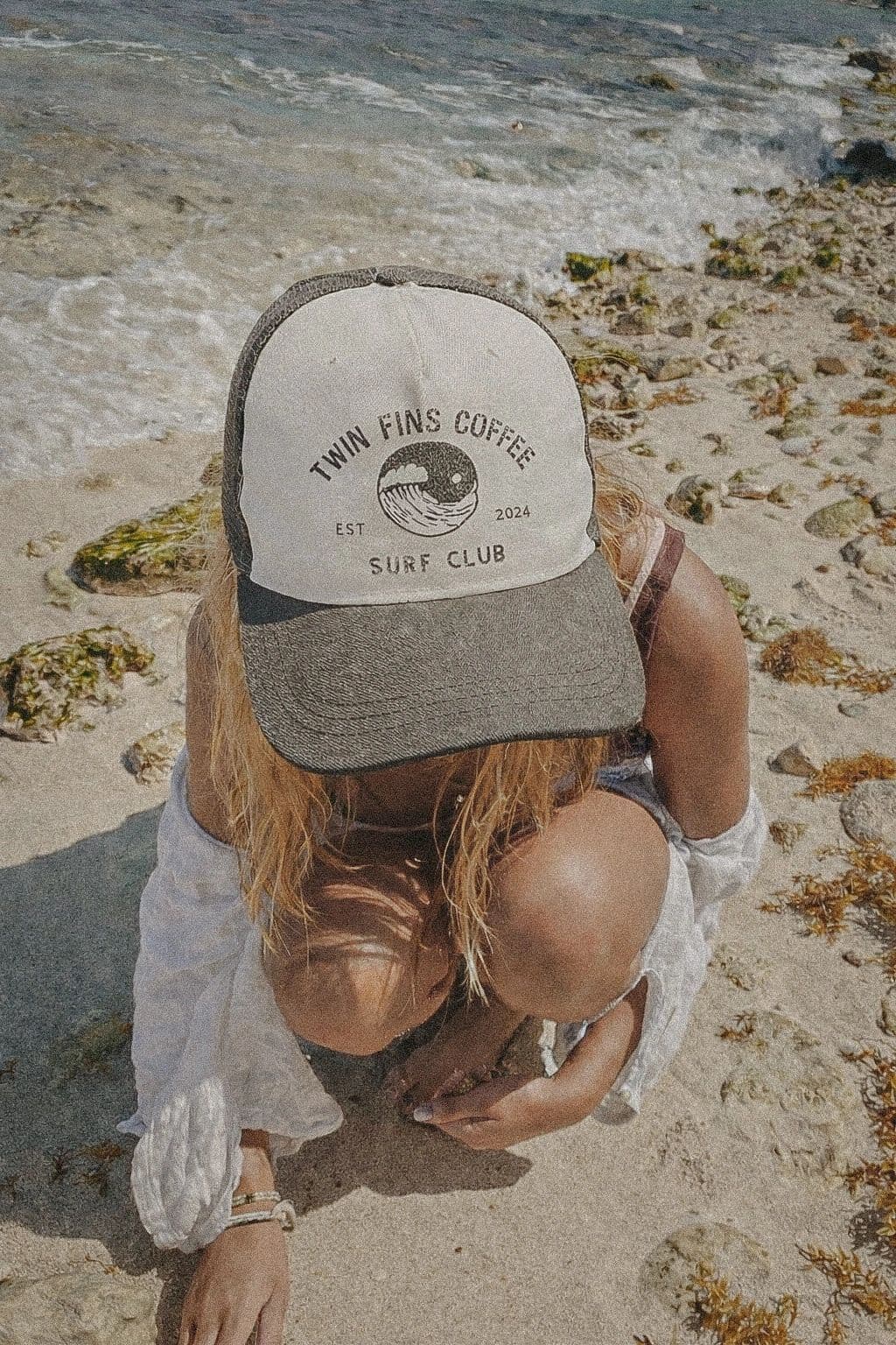 A Twin Fins Surf Club trucker hat, worn beachcombing at the waterline